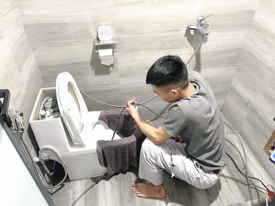 Kỹ thuật viên xử lý bồn cầu bị tắc tại Hoàng Mai bằng dây cáp chuyên dụng