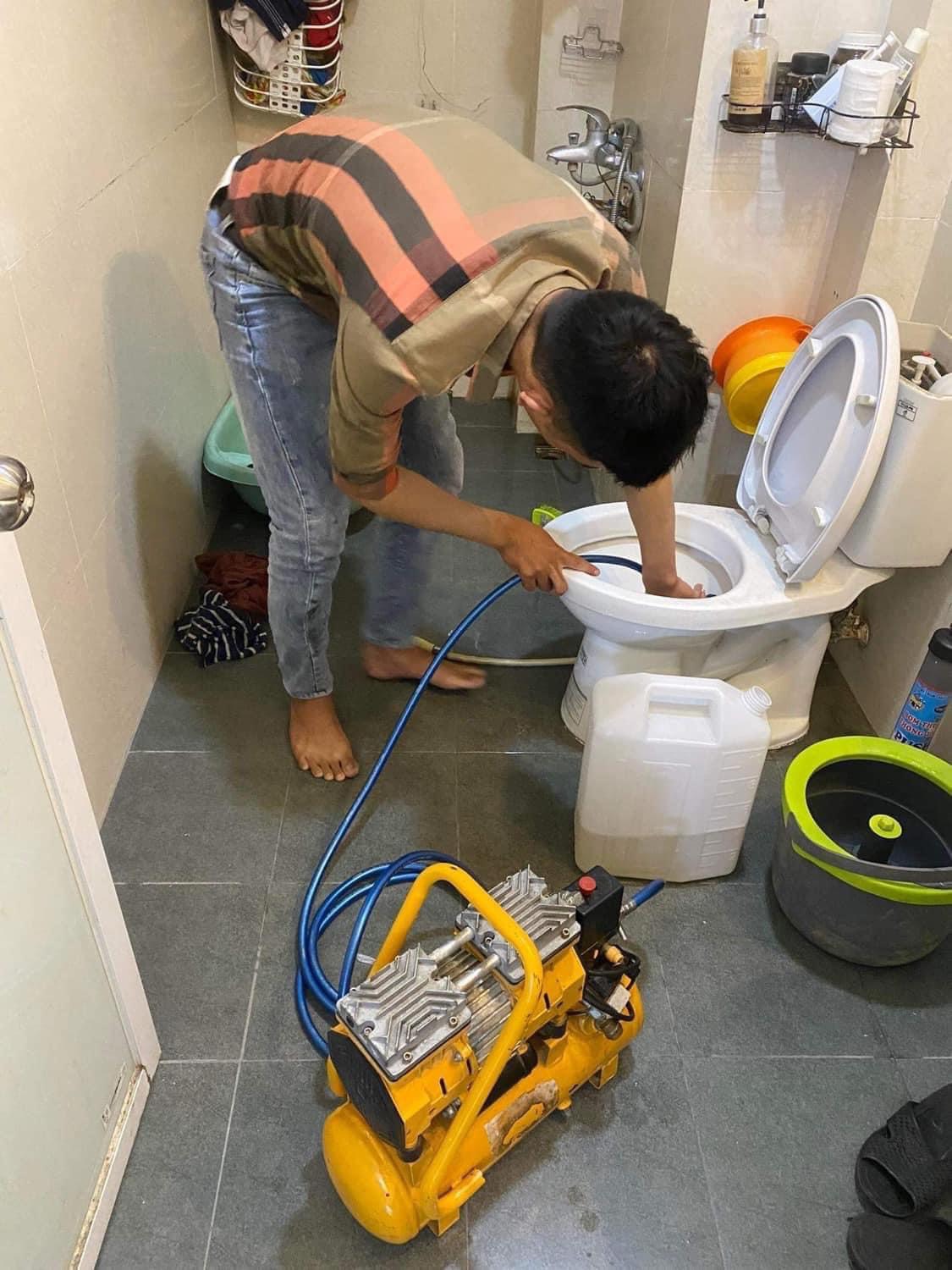 Kỹ thuật viên URENCO dùng máy nén khí thông tắc bồn cầu tại Ba Đình