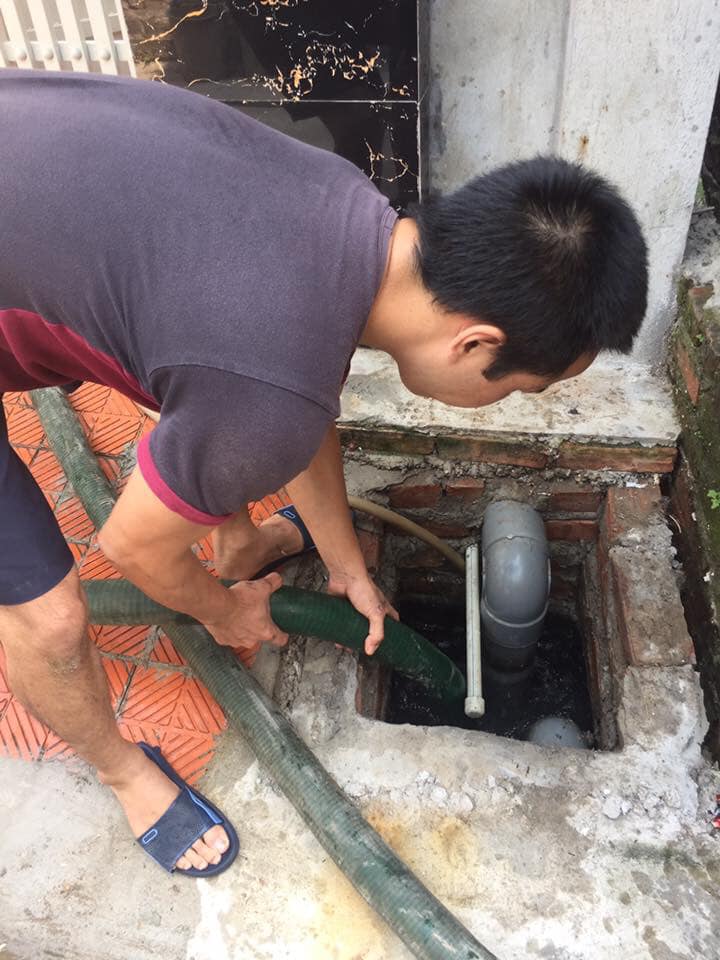 Kỹ thuật viên xử lý hố ga thoát nước tại dãy trọ công nhân Quang Châu